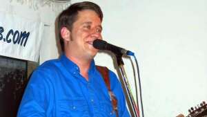 Aaron Traffas singing with an acoustic guitar at Buster's Saloon in Sun City, in south-central Kansas