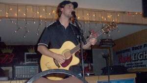 Trevor Burgess singing with an acoustic guitar at Helen's Hilltop in Tonganoxie, in northeast Kansas