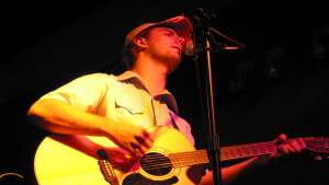 Trevor Burgess singing with an acoustic guitar at Talladega Tavern in Merriam, in northeast Kansas