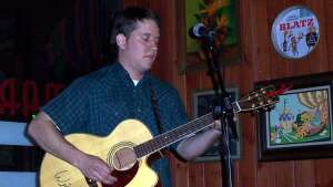 Trevor Burgess singing with an acoustic guitar at Martini's Steak and Chop in Salina, in central Kansas
