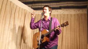 Aaron Traffas singing with an acoustic guitar at Buster's Saloon in Sun City, in south-central Kansas