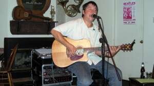 Aaron Traffas singing with an acoustic guitar at Professor's Steakhouse and Saloon in Hays, in central Kansas