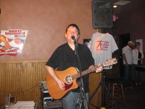 Aaron Traffas singing with an acoustic guitar at Plum Thicket in Kiowa, in south-central Kansas