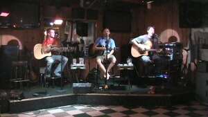 Musicians performing with acoustic guitars at Bobby T's Bar and Grill in Manhattan, in northeast Kansas
