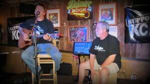 Aaron Traffas singing with acoustic guitar at Woody's Pub and Grub in Lenexa, in east-central Kansas