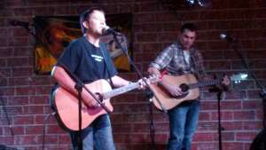 Aaron Traffas and Lucas Maddy performing with acoustic guitars at Longhorns Saloon in Manhattan, in northeast Kansas
