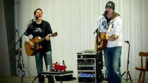 Aaron Traffas and Lucas Maddy performing with acoustic guitars at a private party in Pratt, in south-central Kansas