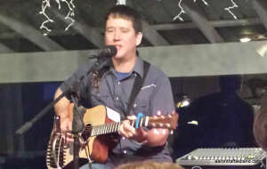 Aaron Traffas singing with acoustic guitar at Buster's Saloon in Sun City, in south-central Kansas