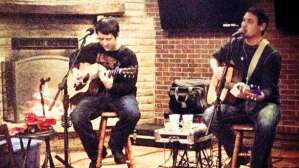 Aaron Traffas and Lucas Maddy with acoustic guitars at Rusty's Last Chance in Manhattan, in northeast Kansas