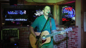 Aaron Traffas singing with an acoustic guitar at Idle Hour in Anthony, in south-central Kansas