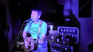 Aaron Traffas singing with an acoustic guitar at Dovie's Bar in Kiowa, in south-central Kansas