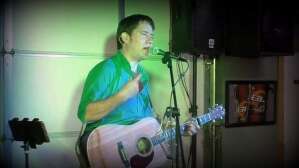 Aaron Traffas singing with an acoustic guitar at Bull Pen in Sharon, in south-central Kansas