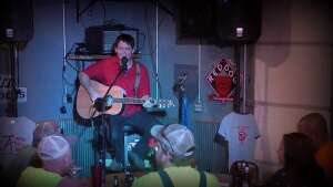 Aaron Traffas singing with an acoustic guitar at Bull Pen in Sharon, in south-central Kansas