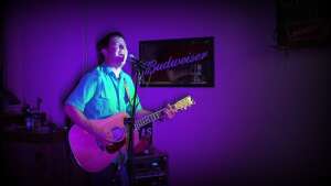 Aaron Traffas singing with an acoustic guitar at Dovie's Bar in Kiowa, in south-central Kansas