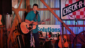Aaron Traffas singing with an acoustic guitar at private party in Medicine Lodge, in south-central Kansas