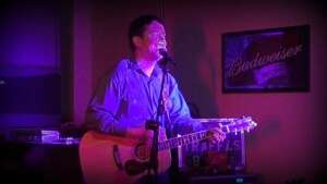 Aaron Traffas singing with an acoustic guitar at Dovie's Bar in Kiowa, in south-central Kansas