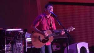 Aaron Traffas singing with an acoustic guitar at Oakley's Family Fun Center in Oakley, in northwest Kansas