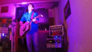 Aaron Traffas singing with an acoustic guitar at Dovie's Bar in Kiowa, in south-central Kansas