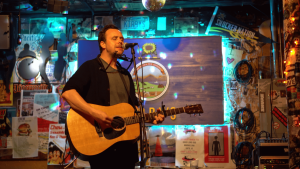 Bryan McPherson singing with an acoustic guitar at Kirby's Beer Store in Wichita, in south-central Kansas