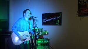 Aaron Traffas singing with an acoustic guitar at Dovie's Bar in Kiowa, in south-central Kansas