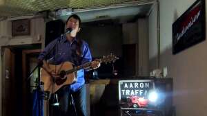 Aaron Traffas singing with an acoustic guitar at Dovie's Bar in Kiowa, in south-central Kansas
