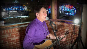 Aaron Traffas singing with an acoustic guitar at Idle Hour in Anthony, in south-central Kansas