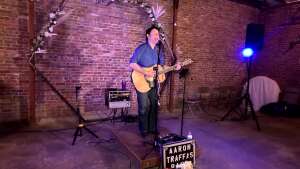 Aaron Traffas singing with an acoustic guitar at private party in St. John, Kansas