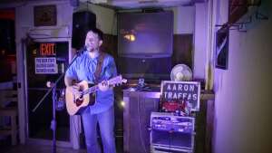 Aaron Traffas singing with an acoustic guitar at Dovie's Bar in Kiowa, in south-central Kansas