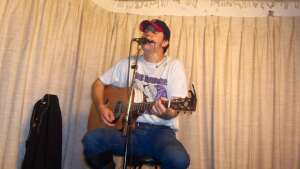 Aaron Traffas singing with an acoustic guitar at Buster's Saloon in Sun City, in south-central Kansas