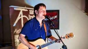 Aaron Traffas singing with an acoustic guitar at Dovie's Bar in Kiowa, in south-central Kansas