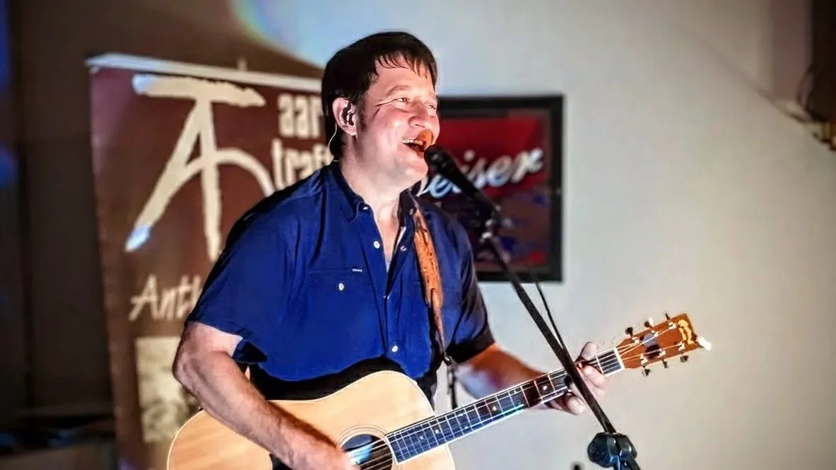 Aaron Traffas singing with an acoustic guitar at Dovie's Bar in Kiowa, in south-central Kansas