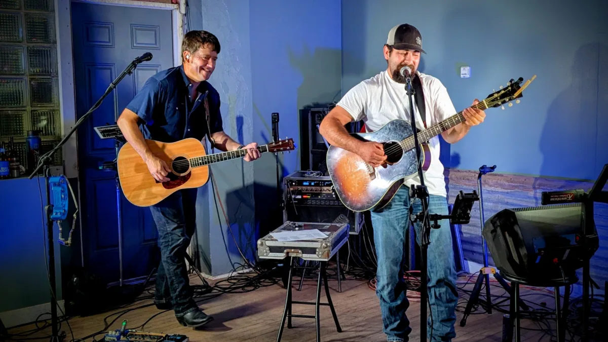 Ruben Corral and Aaron Traffas performing with acoustic guitars at Rucker's Bar in Sharon, in south-central Kansas